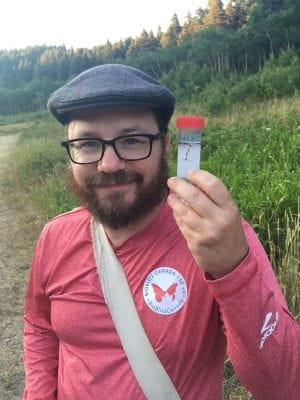 Dr. Cory Sheffield holding an insect specimen collection jar. 